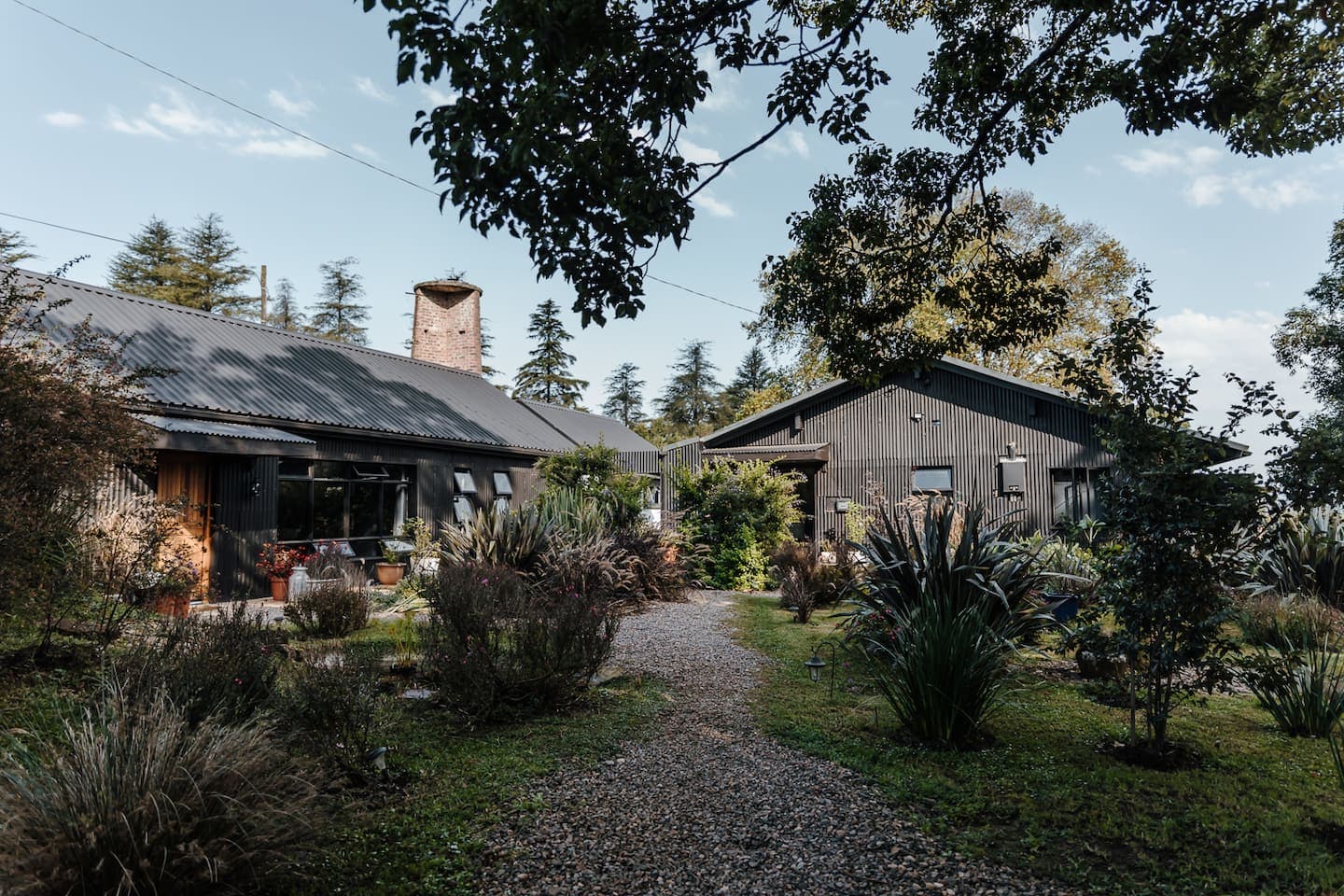 A gravel path running between the cottages through planted garden beds